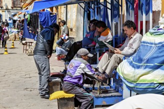 Lively street scene with people at a South American market, a shoeshine boy at work, shoeshine boy
