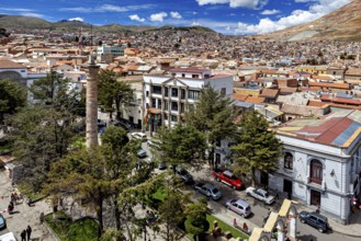 Cityscape with historic buildings and green vegetation under a sunny sky, view over the city of