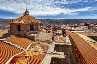Colonial building with traditional roof tiles and mountain backdrop under a blue sky, The roof of