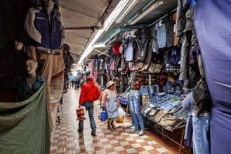 Covered market with lots of clothes and shoppers, people in the streets of Potosi in Bolivia