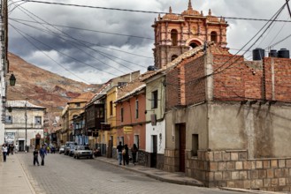 Pretty street with various buildings and hills in the background. The picture shows an urban and