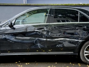 Dented car door after traffic accident, significant bodywork damage to a car in Wuppertal, Germany