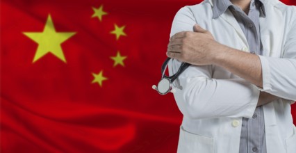 Doctor with stethoscope on arm with China flag behind. National health system of China, concept