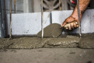 Close-up of a construction worker spreading mortar with a brick trowel