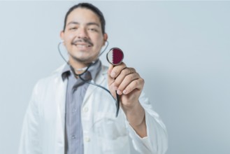 Smiling doctor showing stethoscope with Qatar flag. Qatar national healthcare
