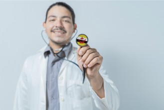 Smiling doctor showing stethoscope with Brunei flag. Brunei national healthcare