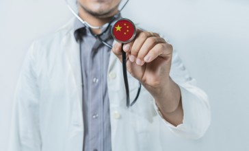 China national healthcare. Doctor showing stethoscope with China flag