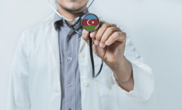 Azerbaijan national healthcare. Doctor showing stethoscope with Azerbaijan flag
