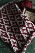 Knitted piece with ball of wool and framed picture with the lettering Behalt ich immer lieb