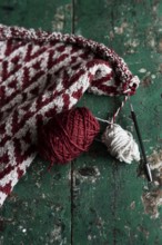 Knitted piece with ball of wool and knitting needle