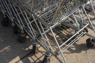 Metal shopping carts with wheels stacked together on urban concrete