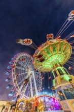 Folk festival time in Stuttgart. Ferris wheel and chain carousel in the evening. The 178th