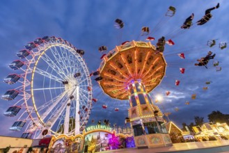 Folk festival time in Stuttgart. Ferris wheel and chain carousel in the evening. The 178th