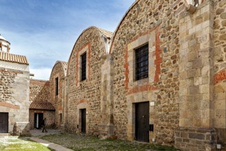 Historic stone buildings with tile accents and curved roofs under a blue sky, The historical museum