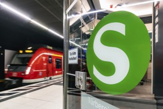 S-Bahn arriving underground at the main station stop. Platform with travellers and logo. Stuttgart,