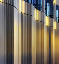 The picture shows a modern office and commercial building at the central station, warm evening