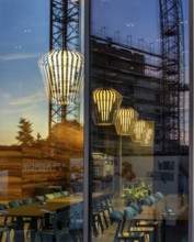 The picture shows the interior of a modern Berlin restaurant, taken in the evening, the scene is