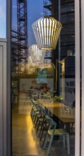 The picture shows the interior of a modern Berlin pub, taken in the evening. The scene is