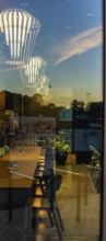 The picture shows the interior of a modern Berlin pub, taken in the evening. The scene is