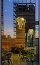 The picture shows the interior of a modern Berlin pub, taken in the evening. The scene is