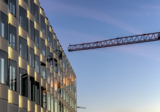 The picture shows a modern building at the main railway station in Berlin with a construction crane