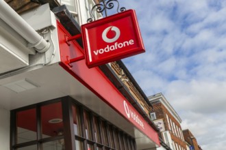 Vodafone sign with logo on shopfront of Vodafone phone shop, Marlborough, Wiltshire, England, UK