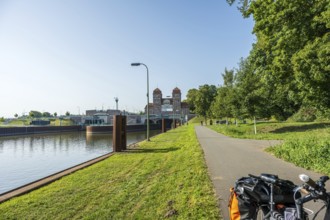 Bicycle standing on a canal path next to a lock, surrounded by green nature, Minden waterway