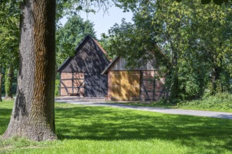 Half-timbered barn with rustic charm surrounded by trees and meadows, Weser cycle path,