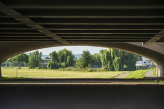View under a bridge onto a summer landscape with willow trees, Minden waterway junction,
