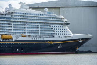 A side view of a cruise ship with distinctive lettering near a shipyard, cruise ship at the Meyer