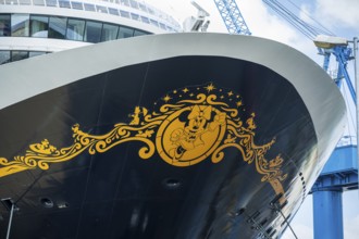 Detailed view of the decorated bow of a cruise ship with a crane in the background, cruise ship in