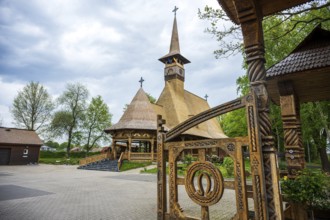 Unique wooden church with ornate carvings and horse shoes on the Tor tor, surrounded by trees, The