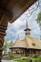 Remarkable wooden church with intricate carvings and a rustic roof against a cloudy sky, the