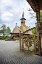 Artfully carved wooden church with horseshoes on the Tor tor in front of a cloudy sky, The Romanian