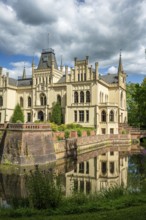 The Gothic castle with moat is picturesquely reflected in the water, Evenburg Castle, Leer, East