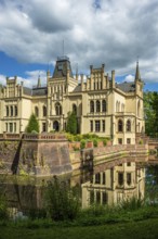 A Gothic castle with moat and towers reflected in the water, Evenburg Castle, Leer, East Frisia