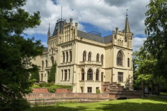 A Gothic castle with architectural details and surrounded by trees, Schloss Evenburg, Leer, East