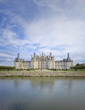 The symmetrical Château de Chambord is reflected in the still water, highlighting its magnificent