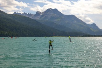 Kitesurfing on Alpine Lake Silvaplana in a Sunny Summer Day with Mountain View in the Swiss Alps in