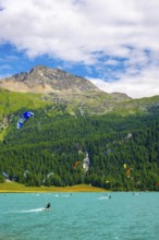 Kitesurfing on Alpine Lake Silvaplana in a Sunny Summer Day with Mountain View in the Swiss Alps in