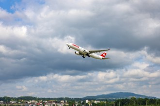Swiss Airlines Passenger Airplane Take Off From the Runway and Flying Against Blue Sky and Clouds