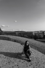 Nature Park with Panoramic View and Modern Building and a Woman Sitting on a Chair in a Sunny