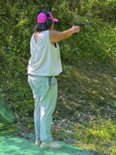 Woman Shooting on an Outdoor IPSC Shooting Range in a Sunny Summer Day in Switzerland