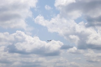 Passenger Airplane Flying Against Blue Sky and Clouds in a Sunny Summer Day From the Airport in
