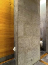 Luxury Men Urinal Bathroom with Wood and Stone Wall in Switzerland