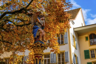 Beautiful Old Town with a Tree and Statue in a Sunny Day in Autumn in Biel, Bienne, Bern Canton,