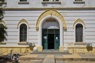 Historic building with arched entrance and small windows, bicycle in front, Historicism, Art Deco,