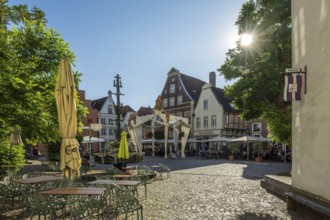 Charming square with half-timbered houses and parasols under a bright blue sky, Warendorf,
