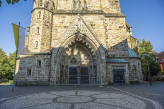 Entrance to a church with richly decorated arch, brick façade and paved forecourt, St Laurentius