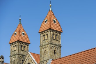 Two Gothic church towers with red tiled roofs under a clear blue sky, St Mary's Church in